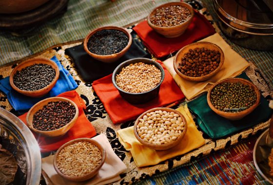 a table topped with bowls filled with different types of beans.